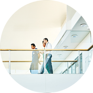 hospital employees walking across a balcony.