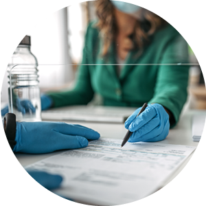 woman behind a desk helping someone fill out paperwork