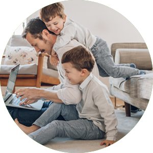 dad working on computer with two kids nearby
